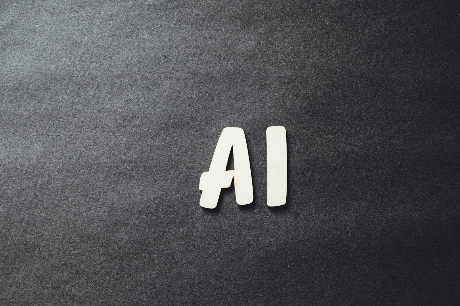 The word AI spelled in letters on dark surface