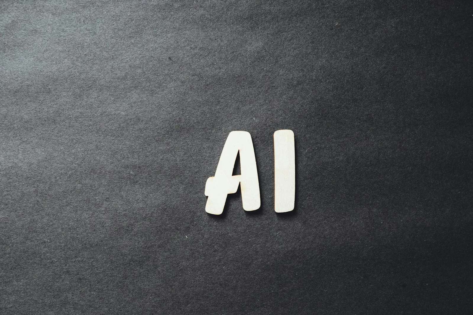 The word AI spelled in letters on dark surface